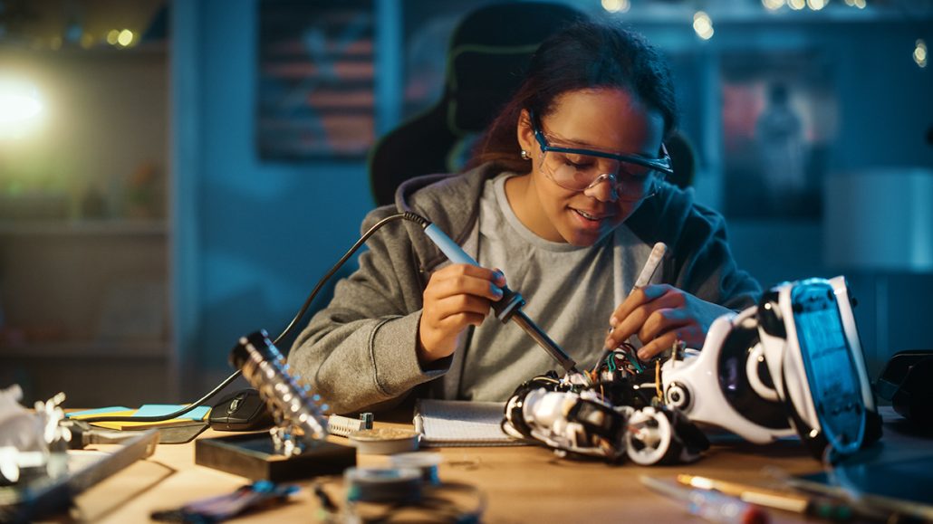 Young lady soldering components in the workshop class